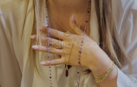 Primo piano elegante di una collana artigianale in stile rosario in argento sterling e pietre naturali, adagiata su un tessuto di velluto.