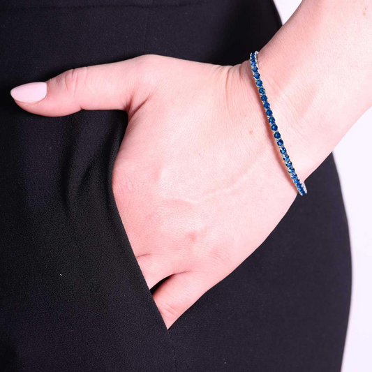 Braccialetto a tennis con zaffiri blu, donna con la mano in tasca.