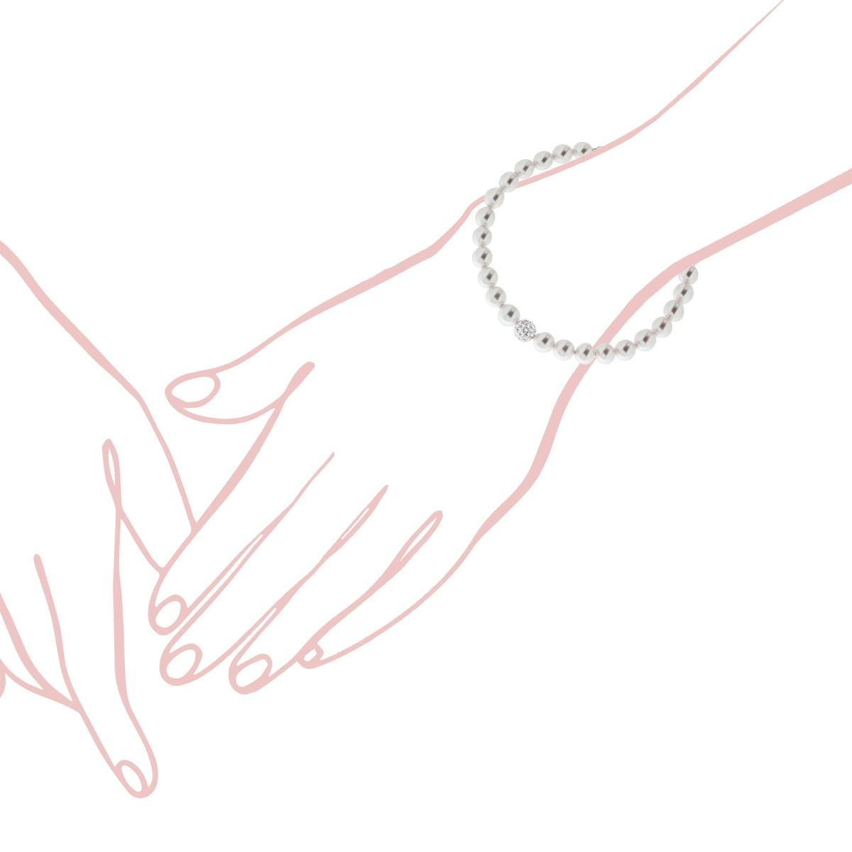 Una mano con un braccialetto di perle e diamanti tiene la mano di un'altra persona.