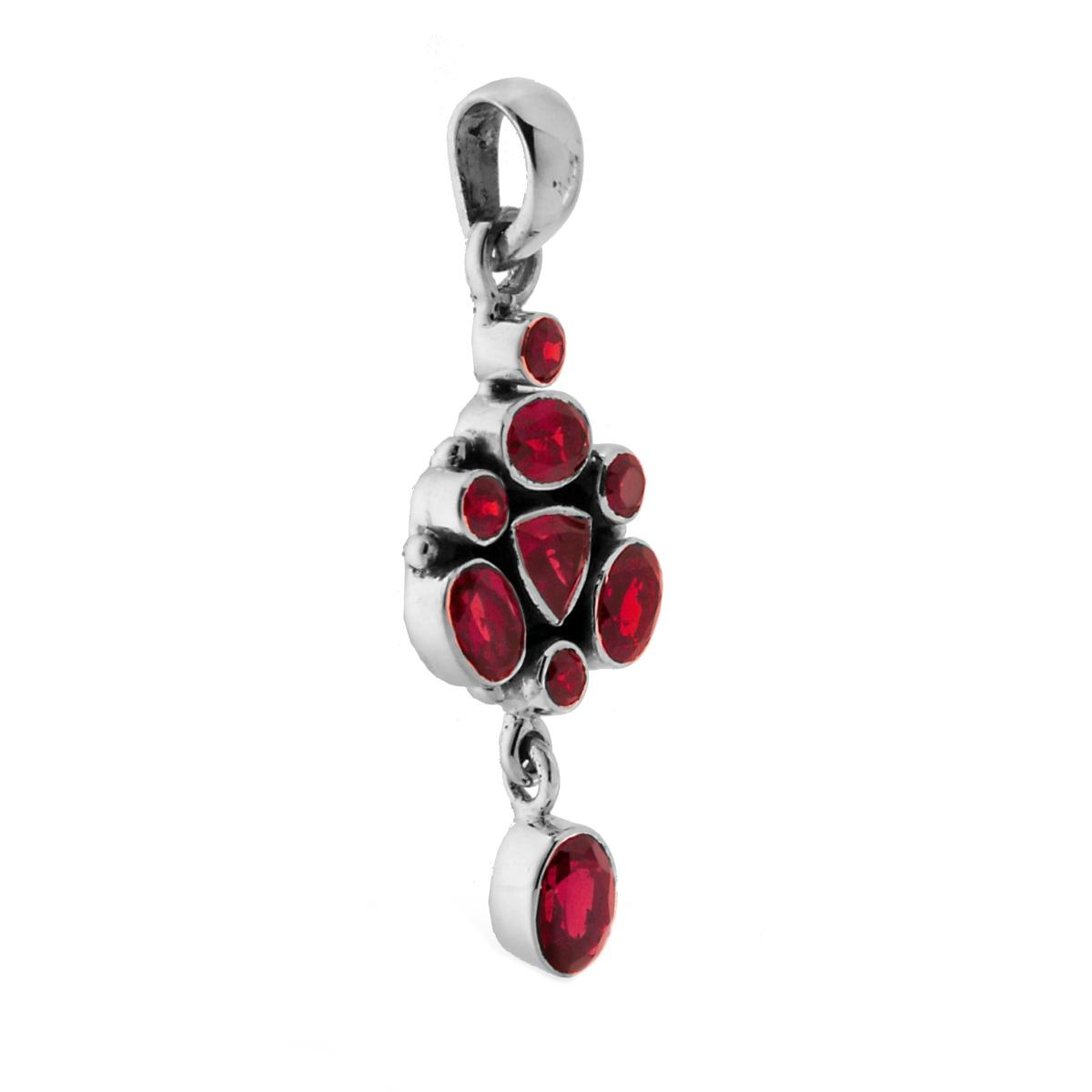 Ciondolo in argento con gemme rosse di varie forme e una catenina.