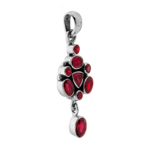 Ciondolo in argento con gemme rosse di varie forme e una catenina.