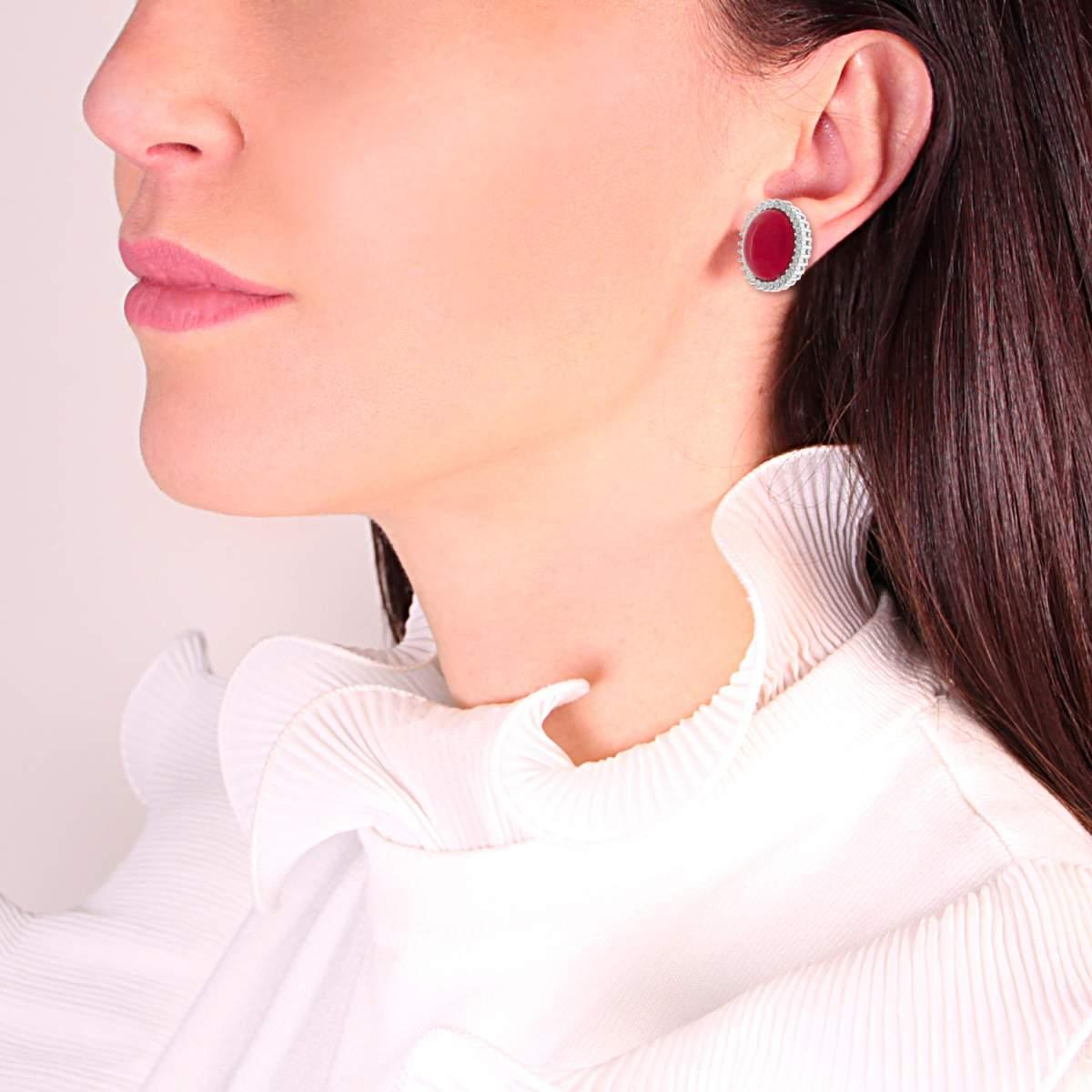 Orecchino ovale in argento con rubino e zirconi indossato da una donna.
