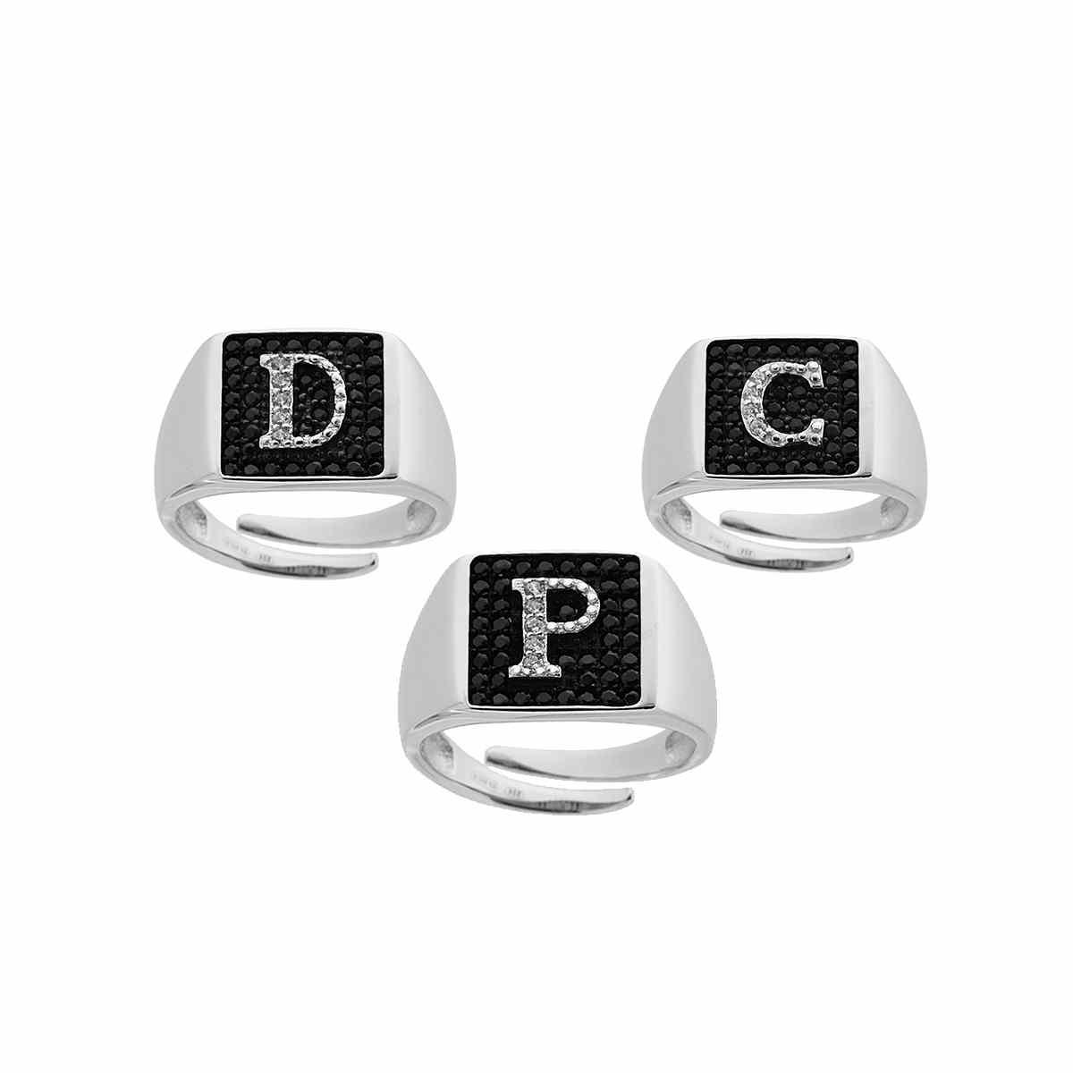 Anello in argento con iniziale D, P, e C in diamanti bianchi su sfondo nero.