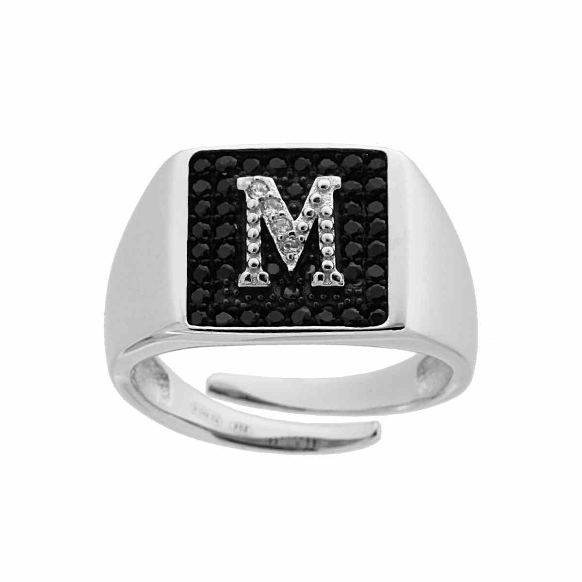 Anello in argento con la lettera 'M' in zirconi e sfondo nero.