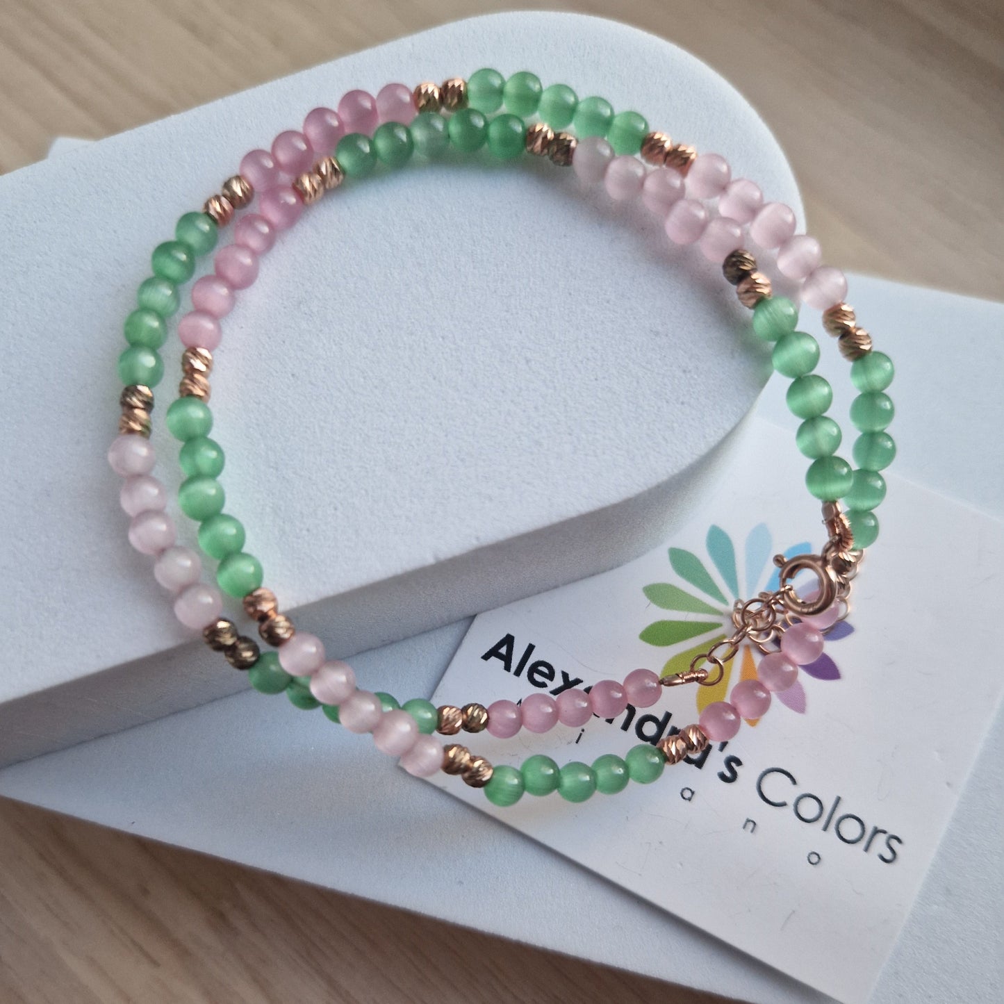 Braccialetto a due fili con perline rosa e verdi, chiusura in oro rosa.