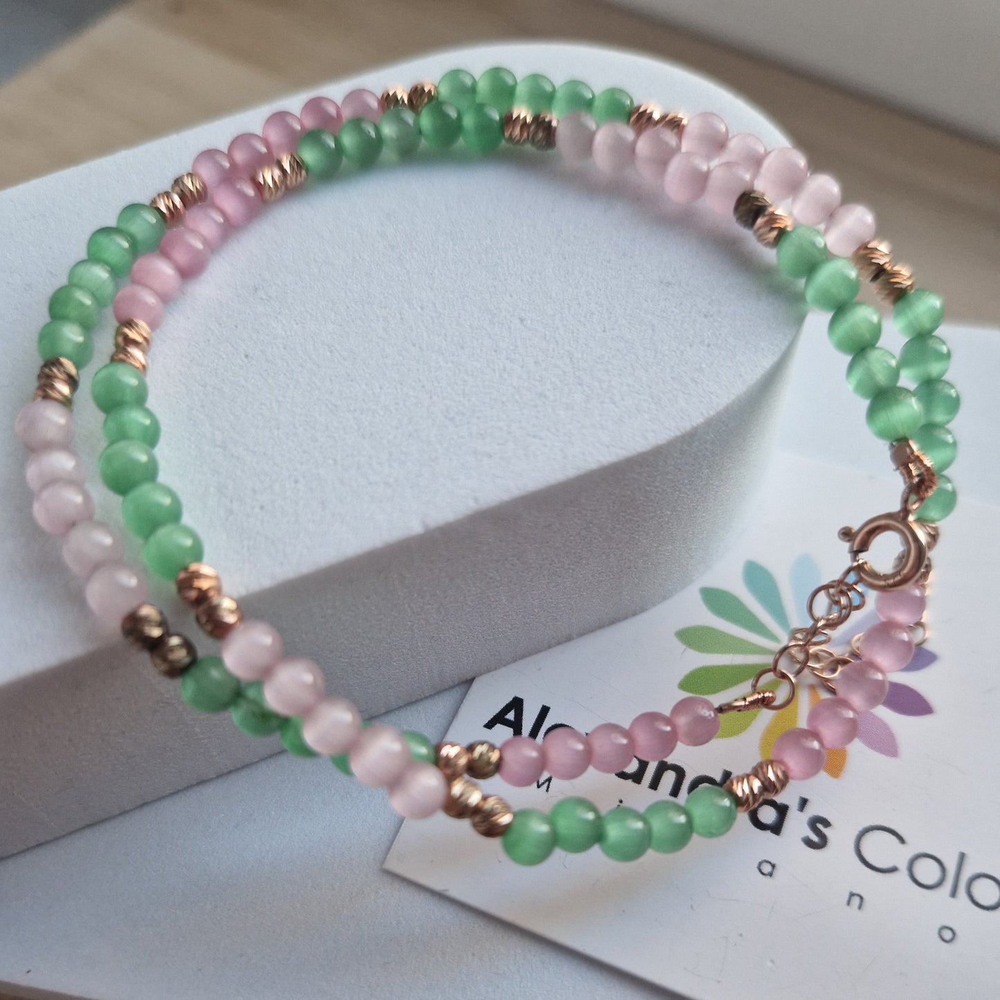 Braccialetto a due fili con perline rosa e verdi, chiusura in oro rosa.