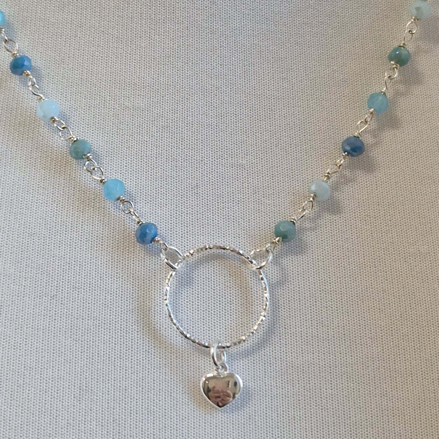 Collana in argento con perline celesti e ciondolo a cuore.