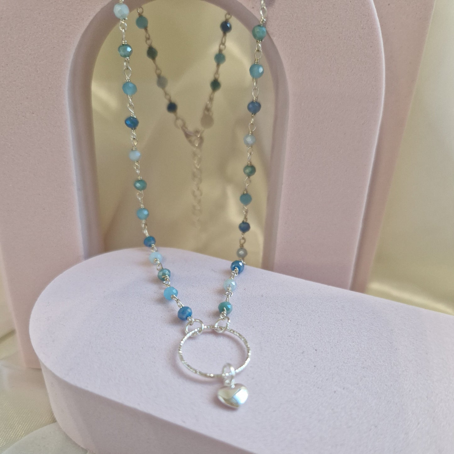 Collana con perline blu e ciondolo a cuore in argento.