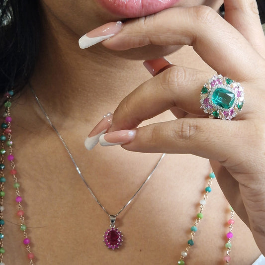 Anello e collana da donna, anello con gemma verde circondata da gemme rosa e bianche, collana con pendente rosa.