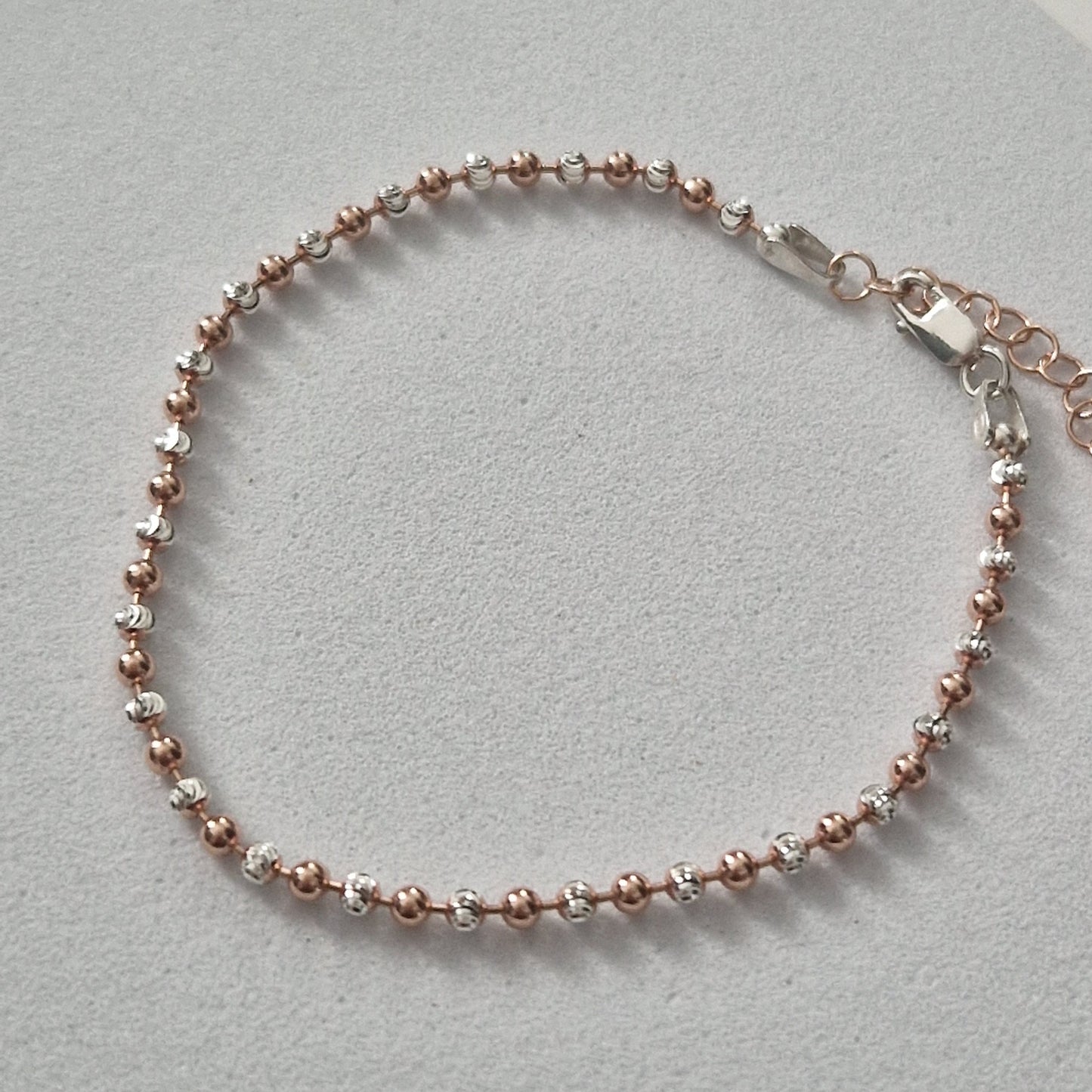 Braccialetto a catena con sfere in oro rosa e argento.
