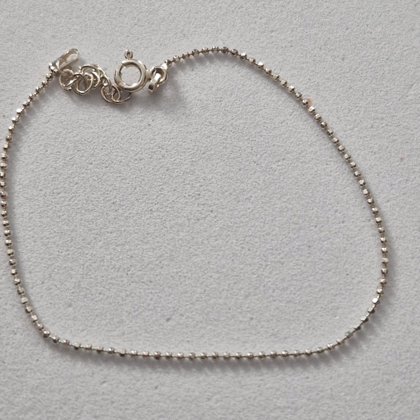 Braccialetto d'argento con una catena di piccole perle e una chiusura a moschettone.