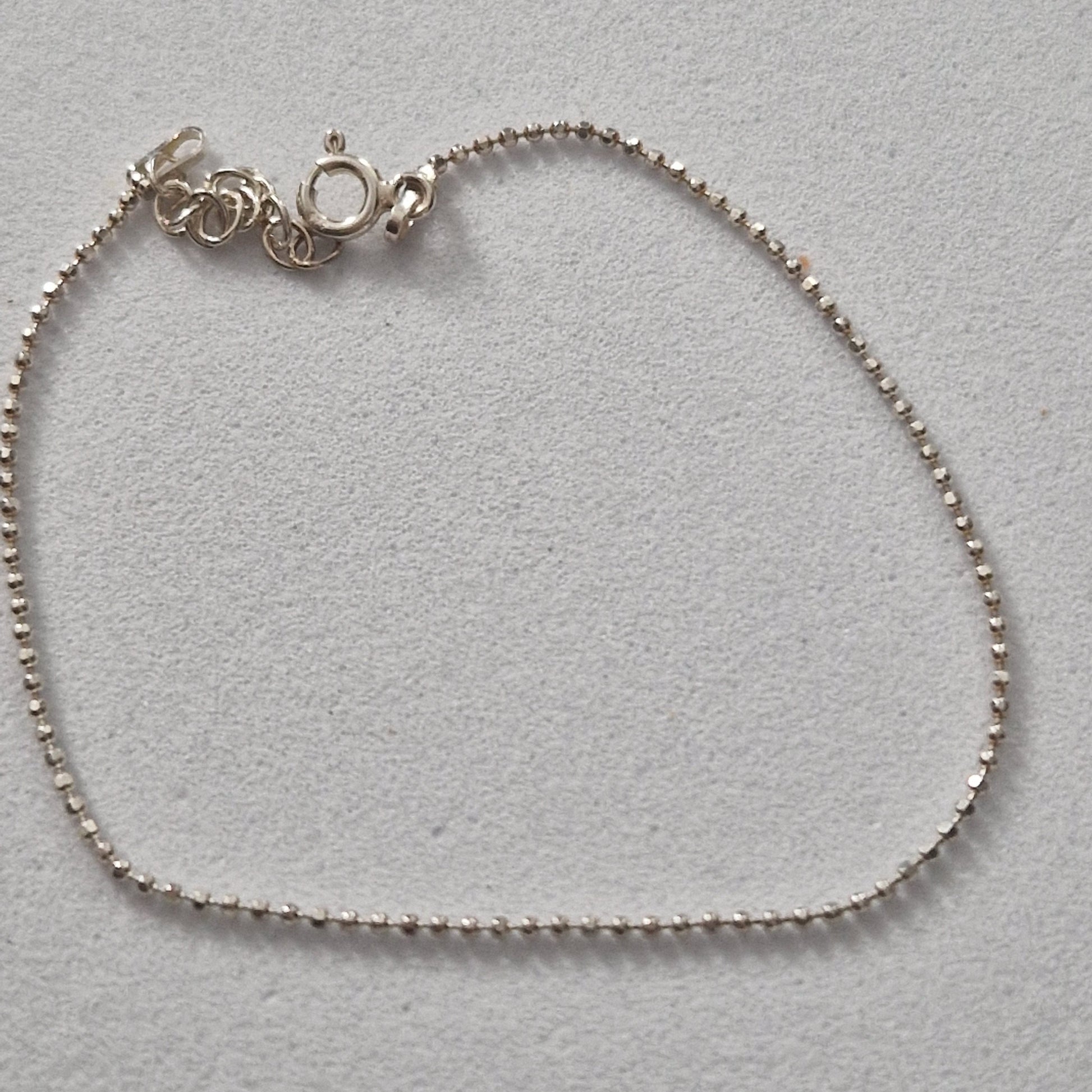 Braccialetto d'argento con una catena di piccole perle e una chiusura a moschettone.