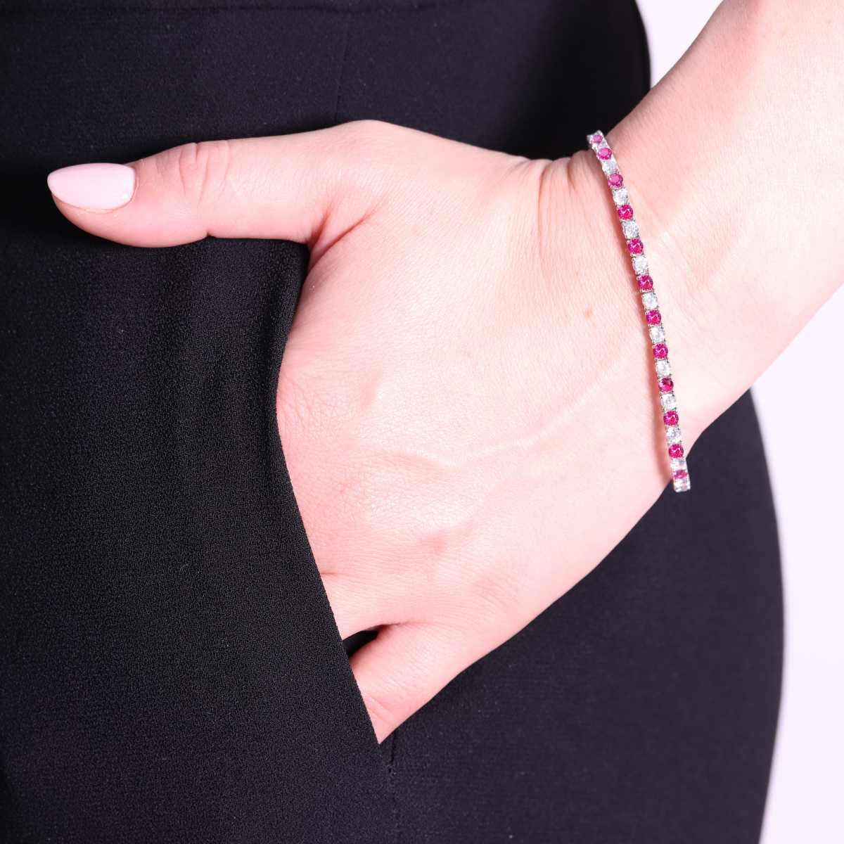 Bracciale tennis con diamanti e rubini su polso.