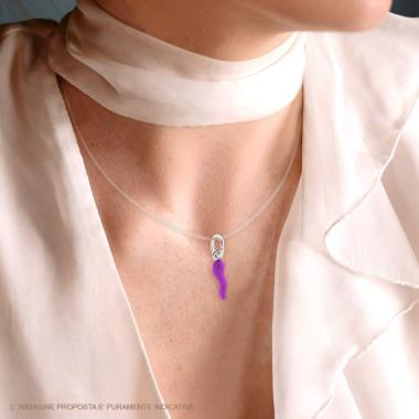 Ciondolo portafortuna a forma di corno viola con un cordino trasparente indossato da una donna.