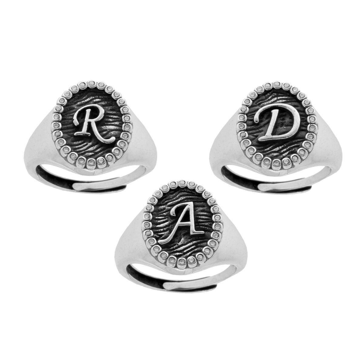 Anello in argento con le iniziali R, D e A, circondate da un motivo a palline.