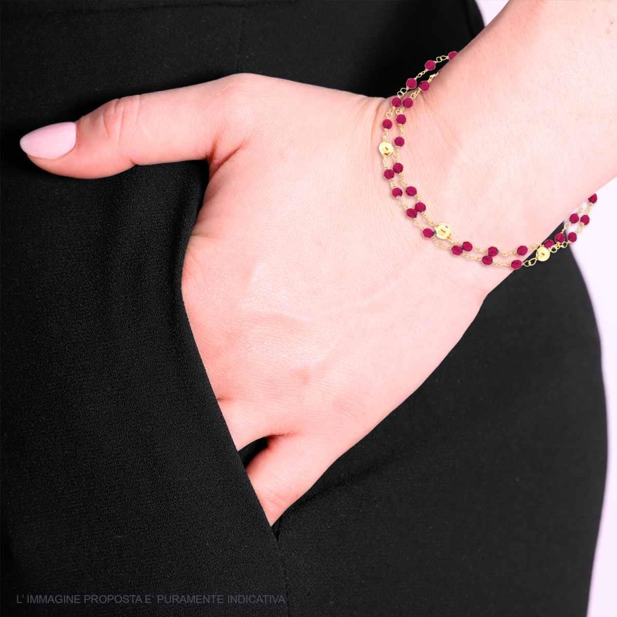 Bracciale in oro e rubini al polso di una donna.