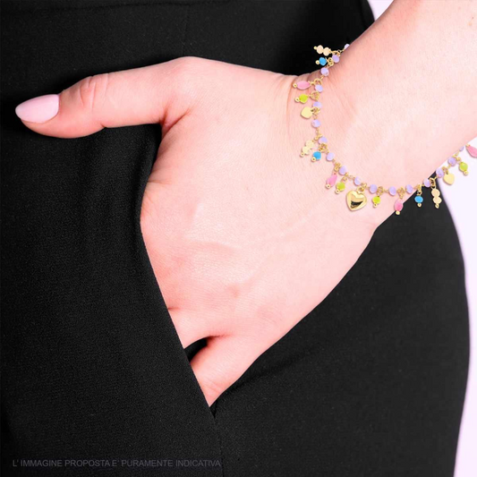 Donna con bracciale a catena dorata con charms a cuore e palline smaltate colorate, in mano in tasca.