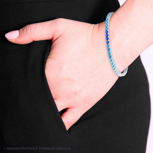 Bracciale in argento con due file di pietre blu, dalla più scura alla più chiara, al polso di una donna.