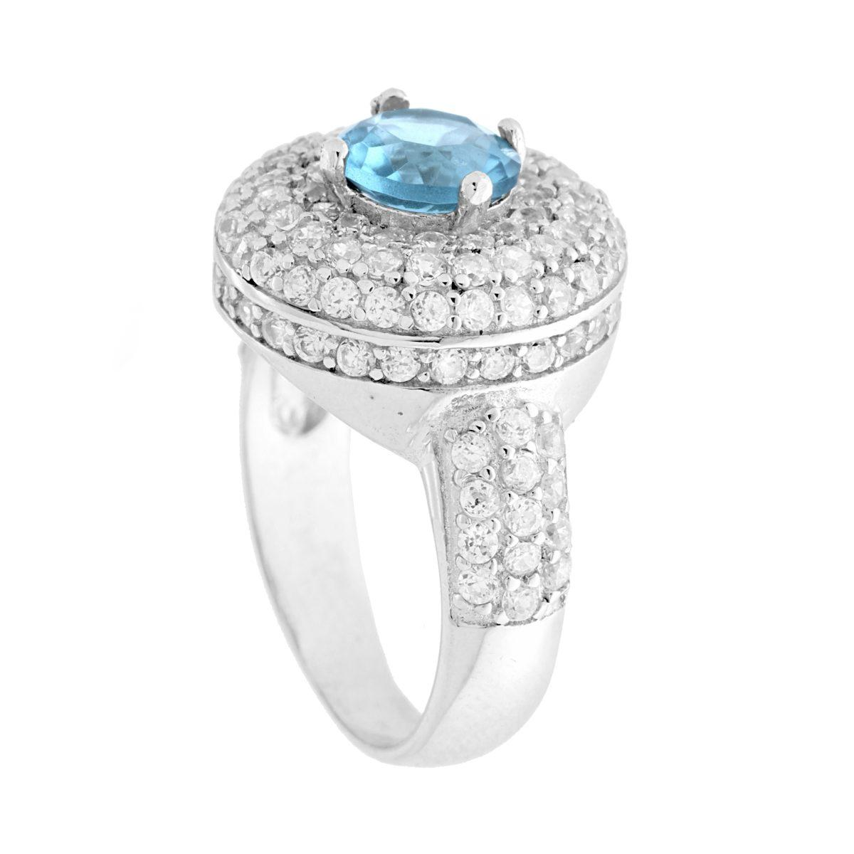 Anello in argento con pietra ovale blu al centro e pavé di zirconi bianchi intorno e sul gambo.