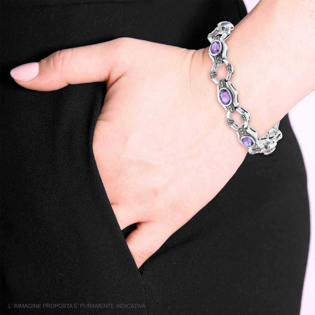 Bracciale in argento con ametiste ovali incastonate, indossato da una donna.