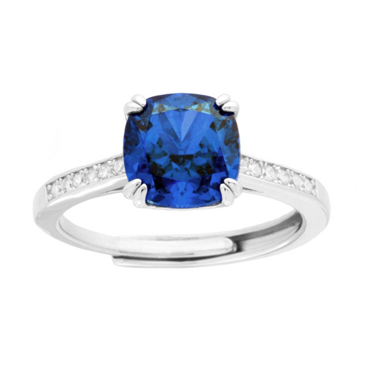 Anello in argento con zaffiro blu taglio cuscino e diamanti laterali.