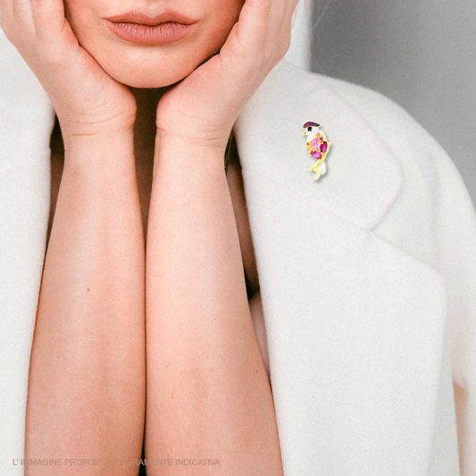 Spilla a forma di pesce colorata su un cappotto bianco.