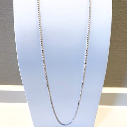 Collana a catena d'argento su un espositore bianco.