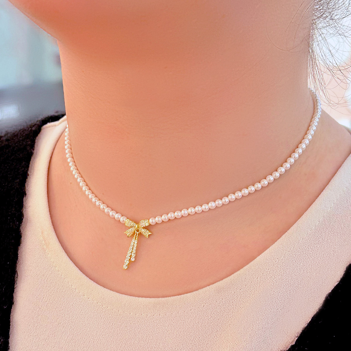 Collana girocollo con perle e fiocco in oro e diamanti.