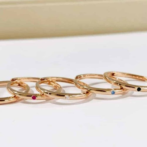 Anelli in oro rosa con gemme di rubino, diamante, zaffiro e onice.