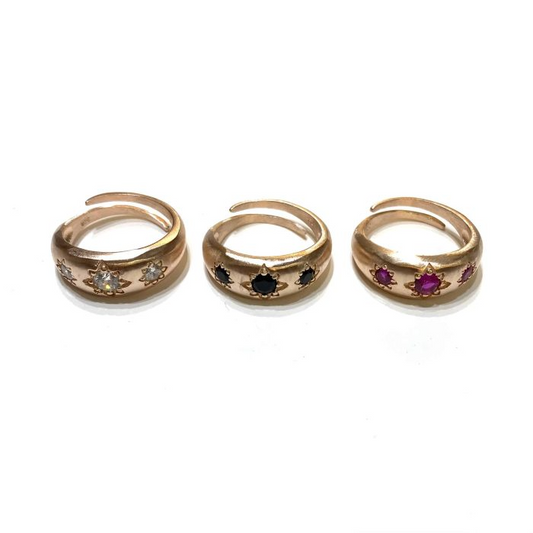 Anelli regolabili in argento placcato oro rosa, con tre stelle incastonate e pietre bianche, nere e rosa.