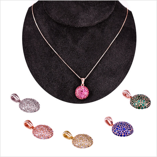 Ciondoli ovali e rotondi con pavé di zirconi su fondo bianco.