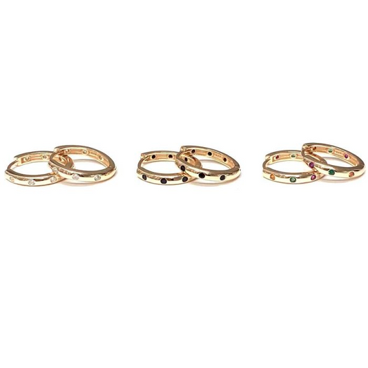 Tre paia di orecchini a cerchio in oro con diamanti incastonati, pietre nere e pietre multicolori.