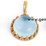 Ciondolo in oro con una pietra cabochon azzurra, incastonata in una base lavorata a corona.