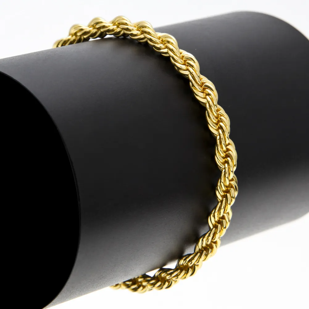 Braccialetto a catena d'oro a corda su un supporto nero cilindrico.