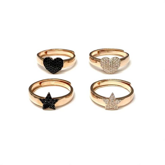 Anelli in oro rosa con cuore e stella, alcuni con pavé di zirconi neri e altri bianchi.