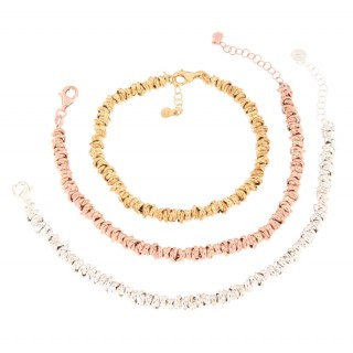 Tre bracciali a catena, uno argento, uno oro rosa e uno oro giallo.