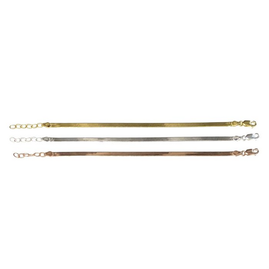 Bracciali a maglia snake piatta in tre finiture: oro, argento e oro rosa, con chiusura a moschettone e catenella.