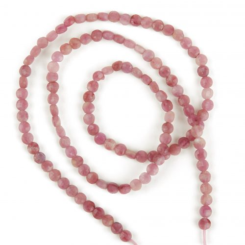 Fili di tormalina rosa, perle sfaccettate e irregolari su sfondo bianco.