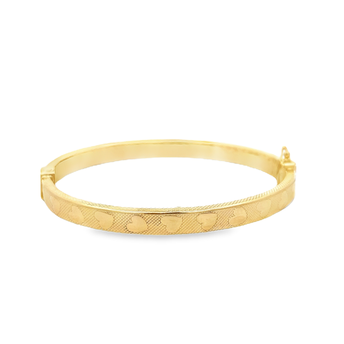 Bracciale rigido in oro giallo con decoro a cuori e texture a rombi, chiusura con gancio laterale.
