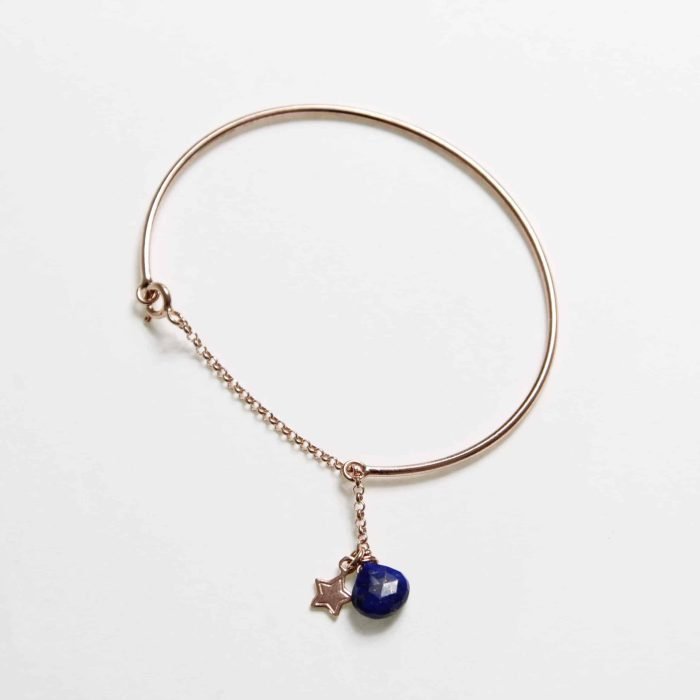 Bracciale in oro rosa con pendente di lapislazzuli blu intenso e charm a forma di stella.