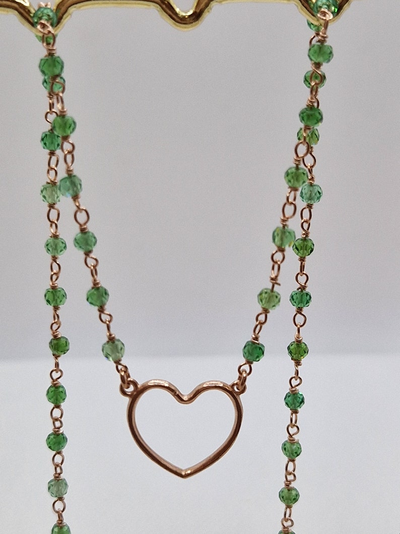 Collana in oro con ciondolo a cuore e perline verdi, catena a due fili.