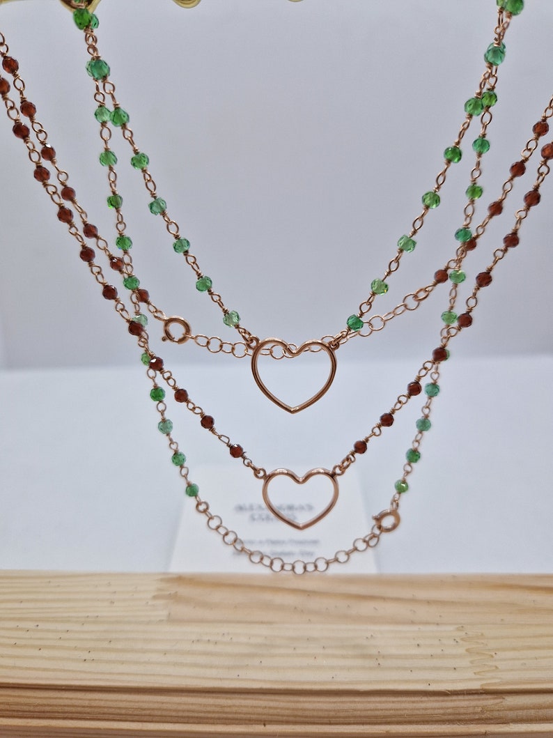 Collana a doppio strato con cuori e perle verdi e marroni.