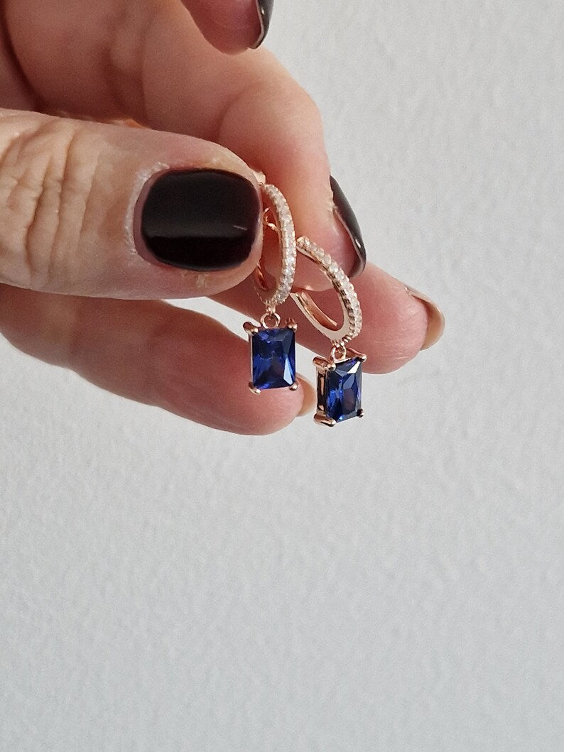 Orecchini a cerchio in oro rosa con zirconi e pendenti rettangolari in zaffiro blu.