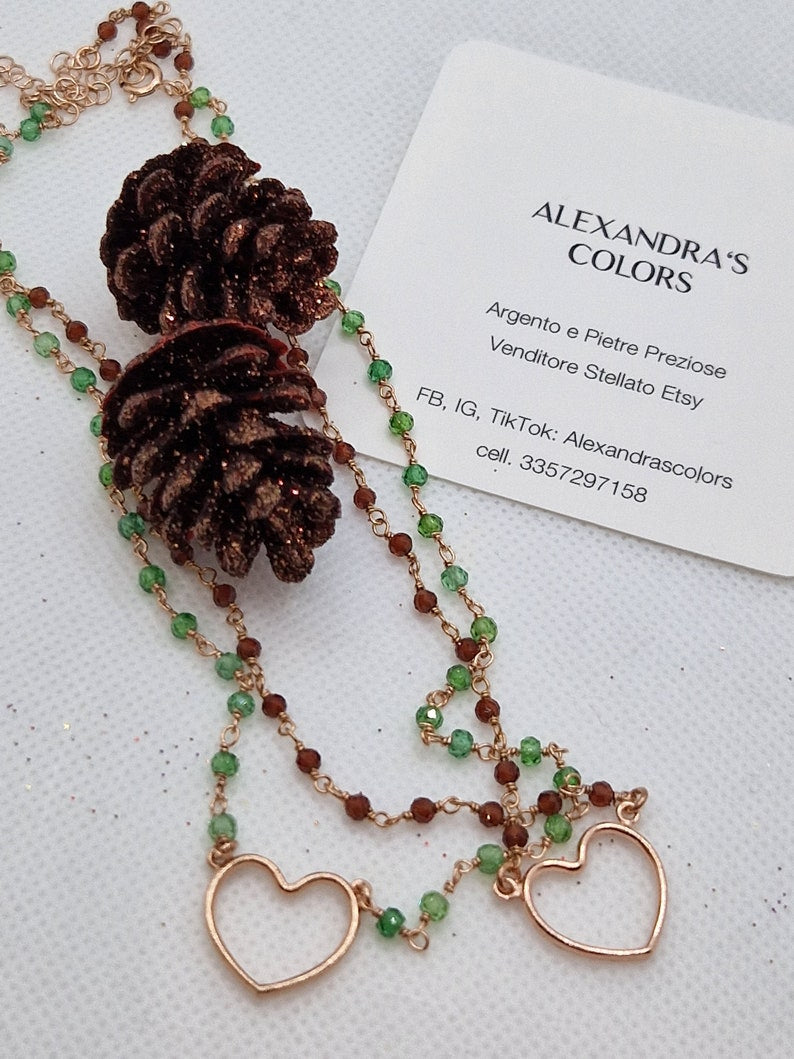 Collana in argento con perline verdi e marroni, ciondoli a forma di cuore e pigne, e biglietto da visita "Alexandra's Colors".