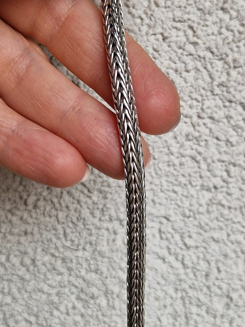 Maglia a catena in argento o metallo intrecciato.