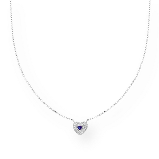 Collana in oro bianco con ciondolo a cuore. Il cuore è decorato con piccoli diamanti e un zaffiro blu a forma di cuore al centro.