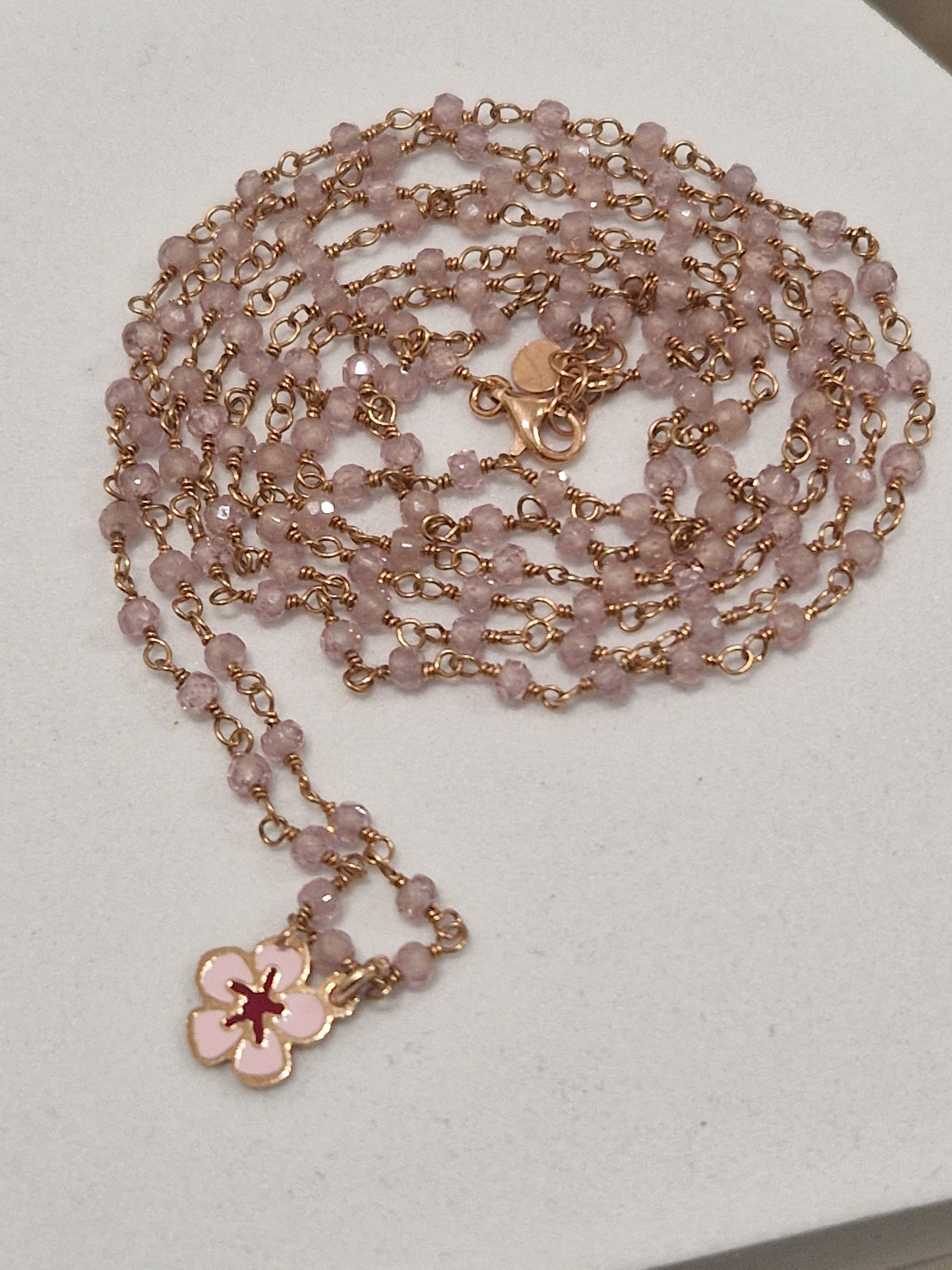 Collana rosa con perline e ciondolo a fiore di ciliegio.