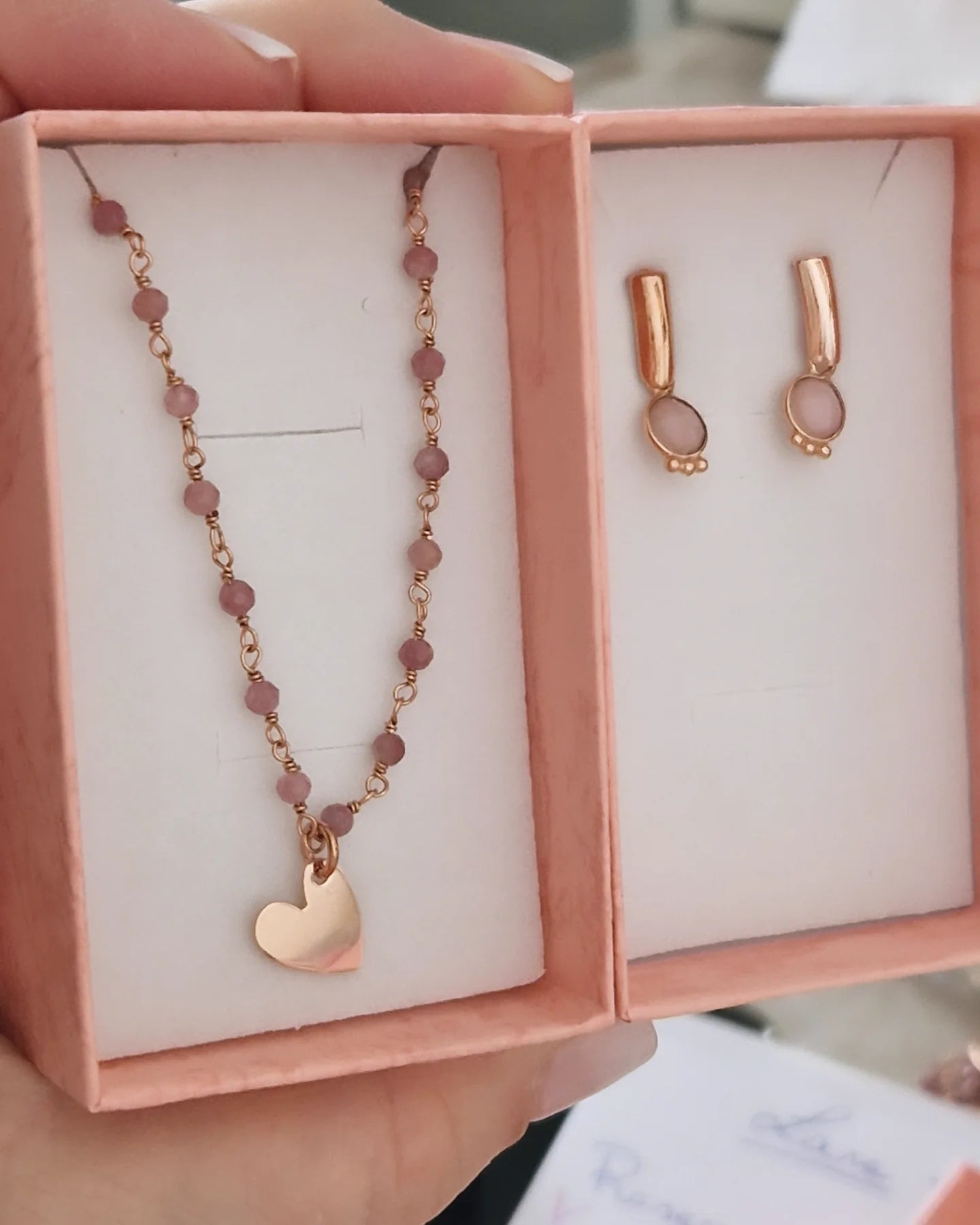Collana e orecchini in oro rosa in una scatola regalo.