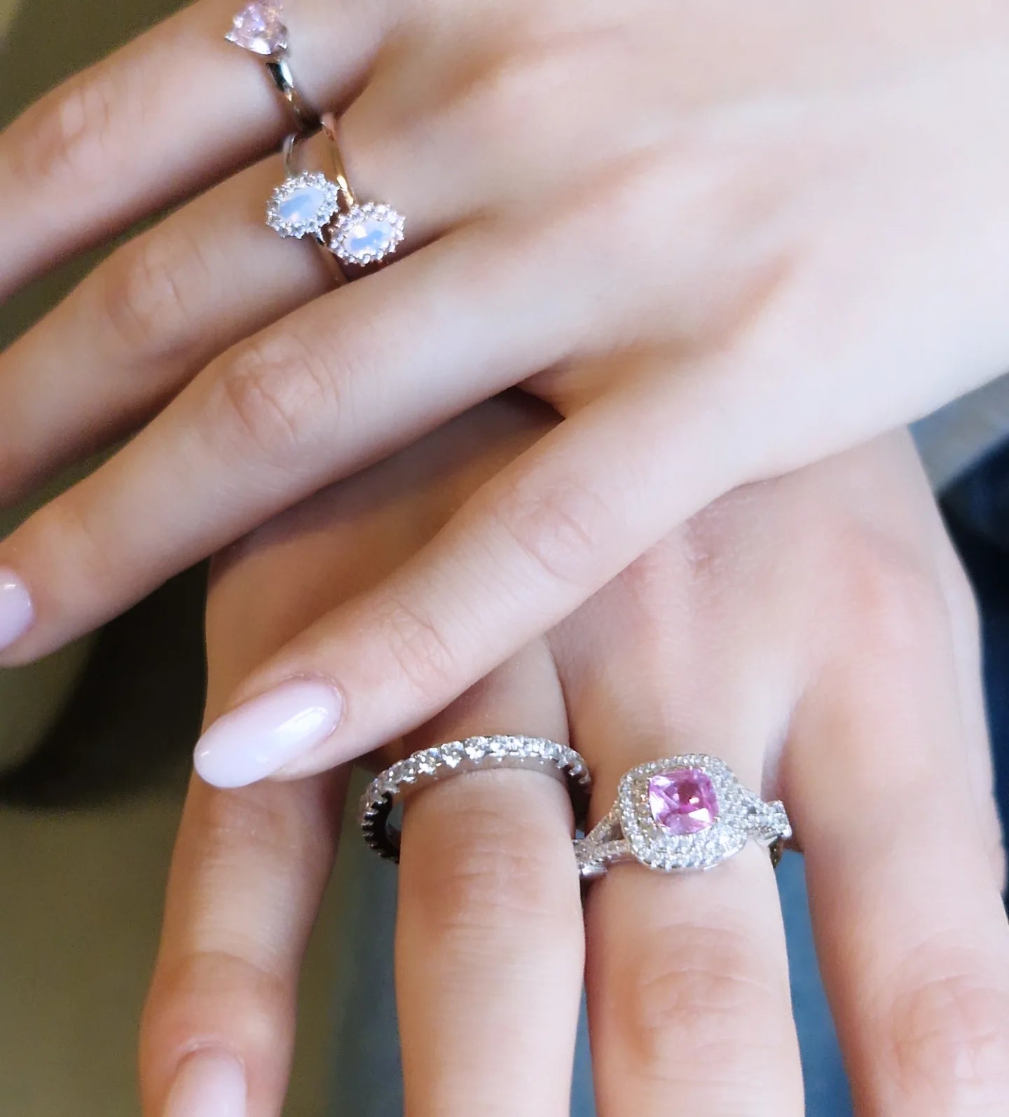 Anelli con pietre preziose: una donna indossa due anelli, uno con zaffiro rosa, l'altro con diamante.