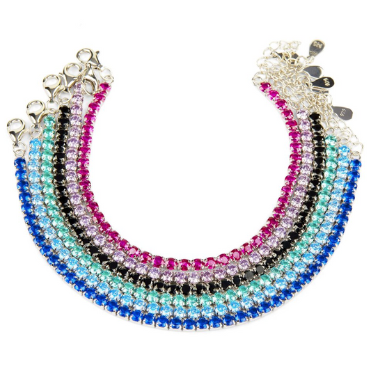Cinque bracciali tennis con gemme colorate: blu, azzurro, verde acqua, nero e rosa/fucsia.